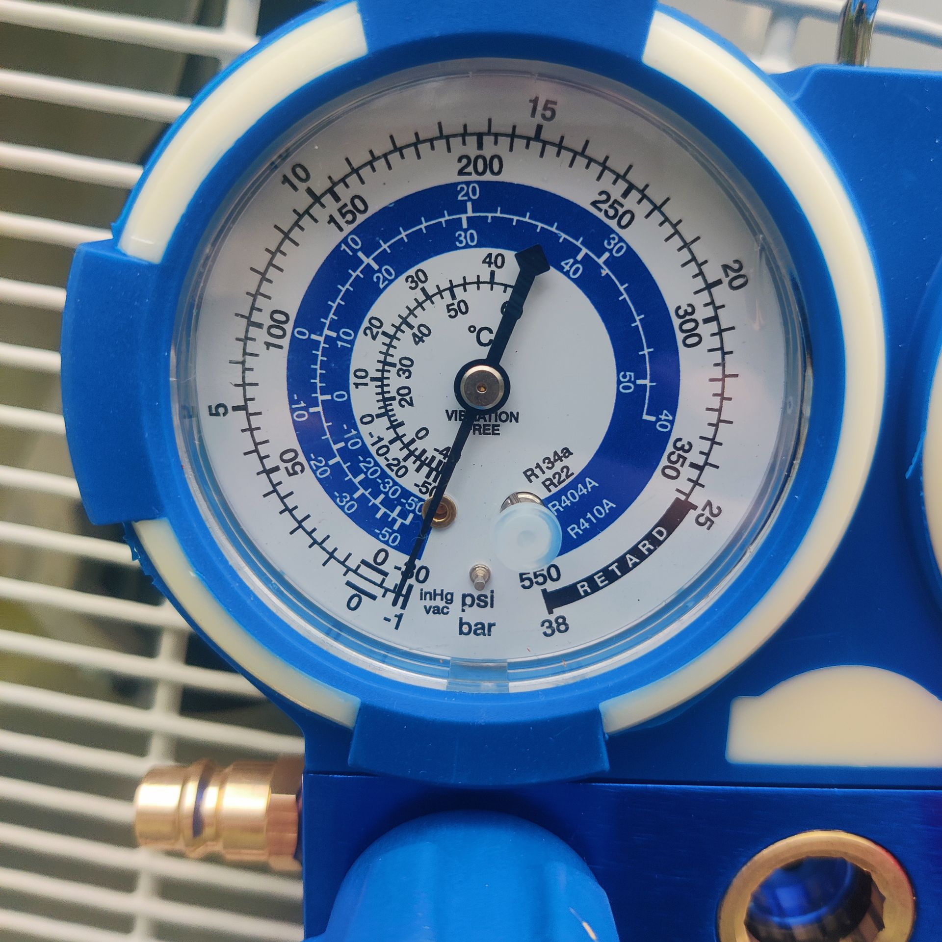 Close-up of a blue analog pressure gauge with a black needle and white dial markings.