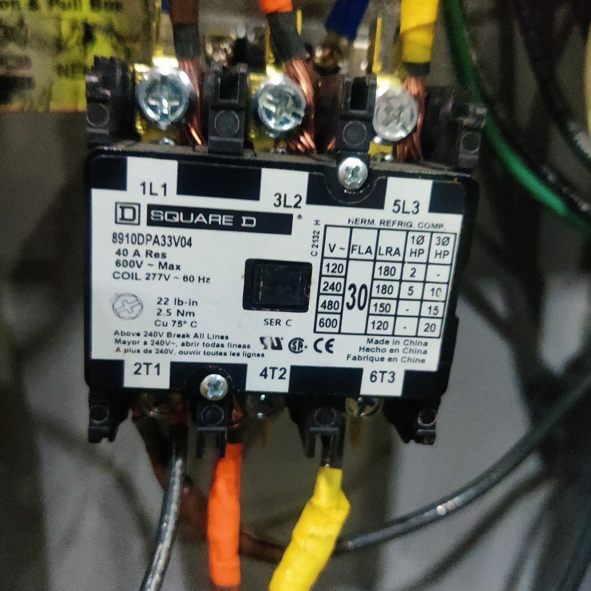 Close-up of a Siemens electrical contactor with connected wires and labeled terminals.