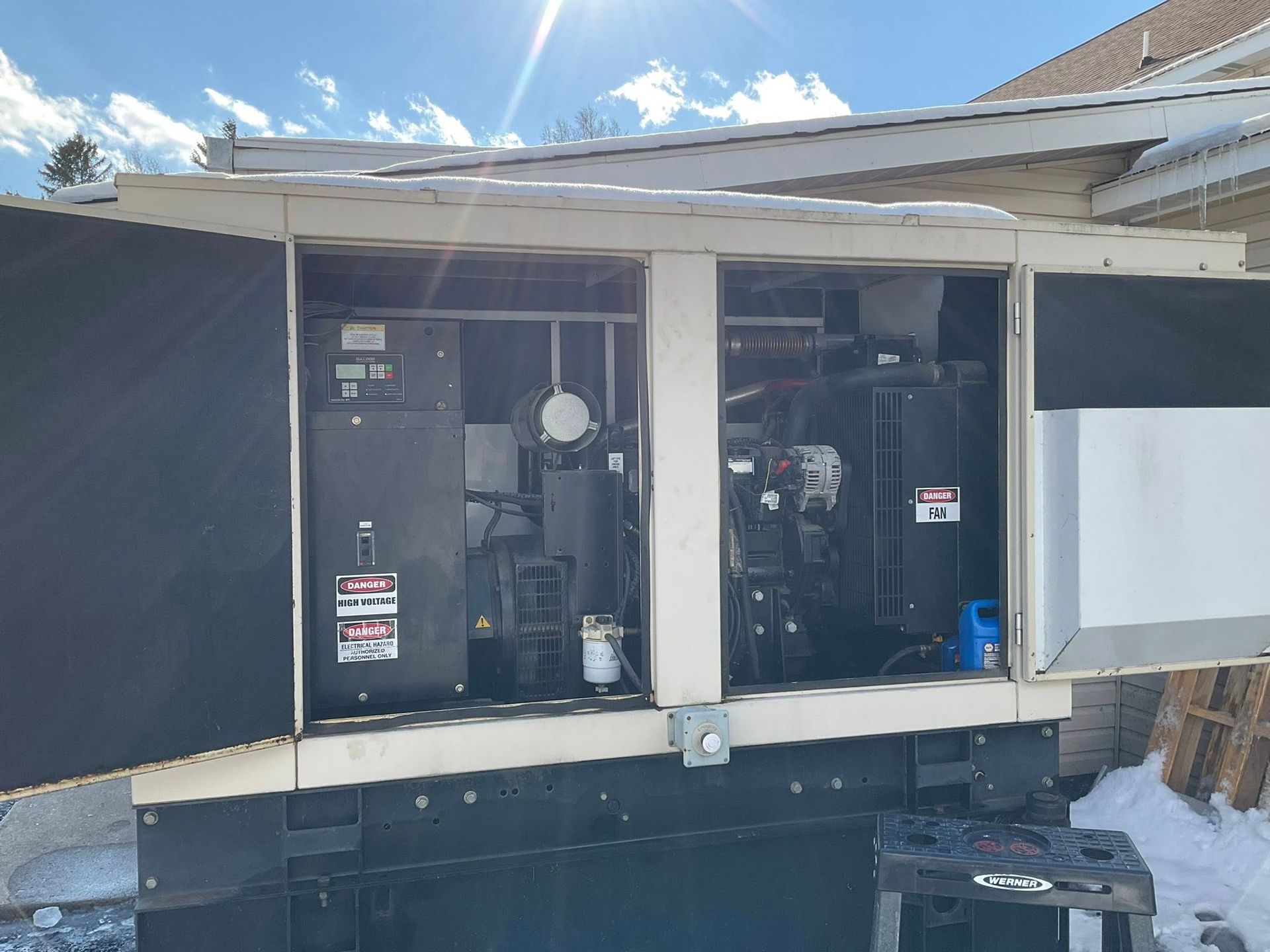 Outdoor HVAC units inside a covered service bay beneath a white roof.