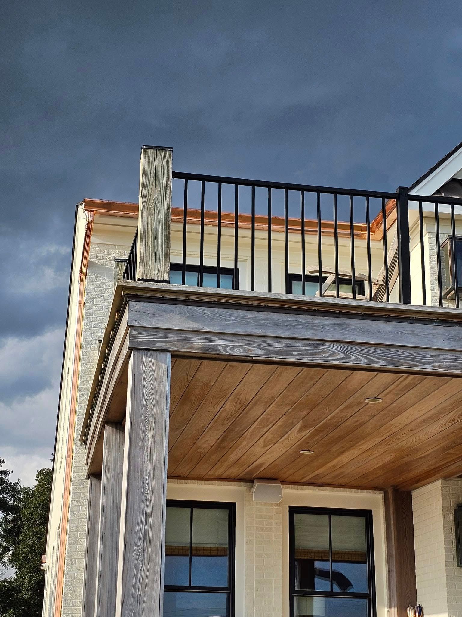 A multi-story building with a balcony, under a stormy gray sky.