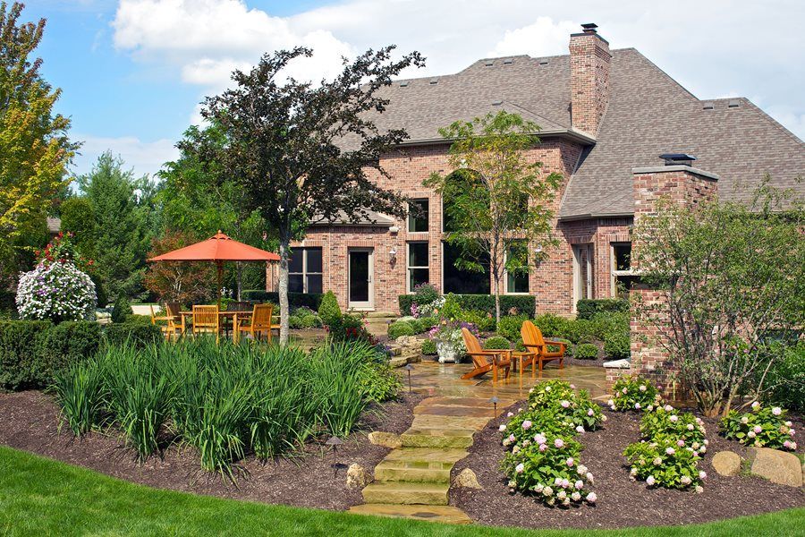 a home with beautiful landscaping in the backyard located in bentonville, ar
