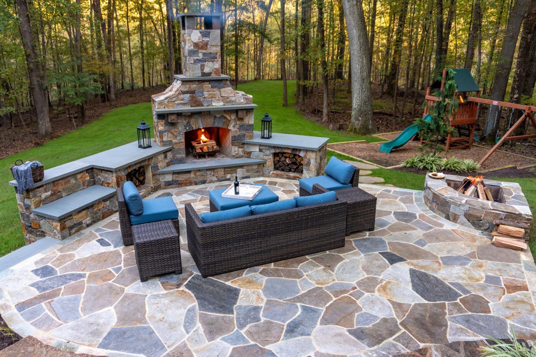 a stone patio and fireplace in a backyard in bella vista, ar