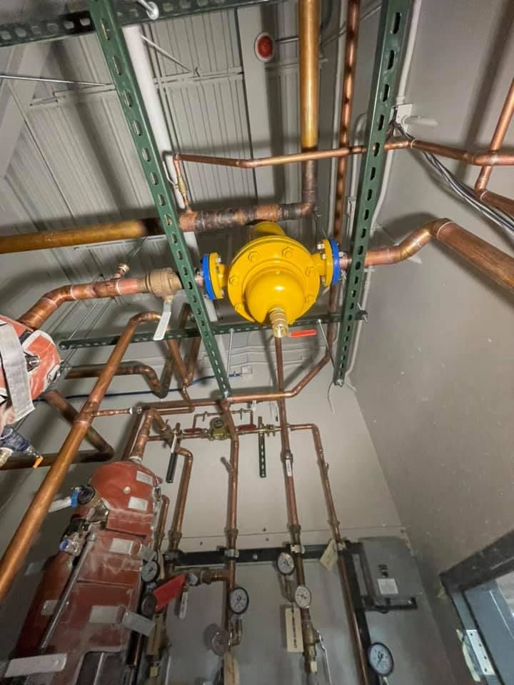 Ceiling-mounted yellow industrial valve and copper pipes in a mechanical room Ceiling-mounted yellow industrial valve and copper pipes in a mechanical room
