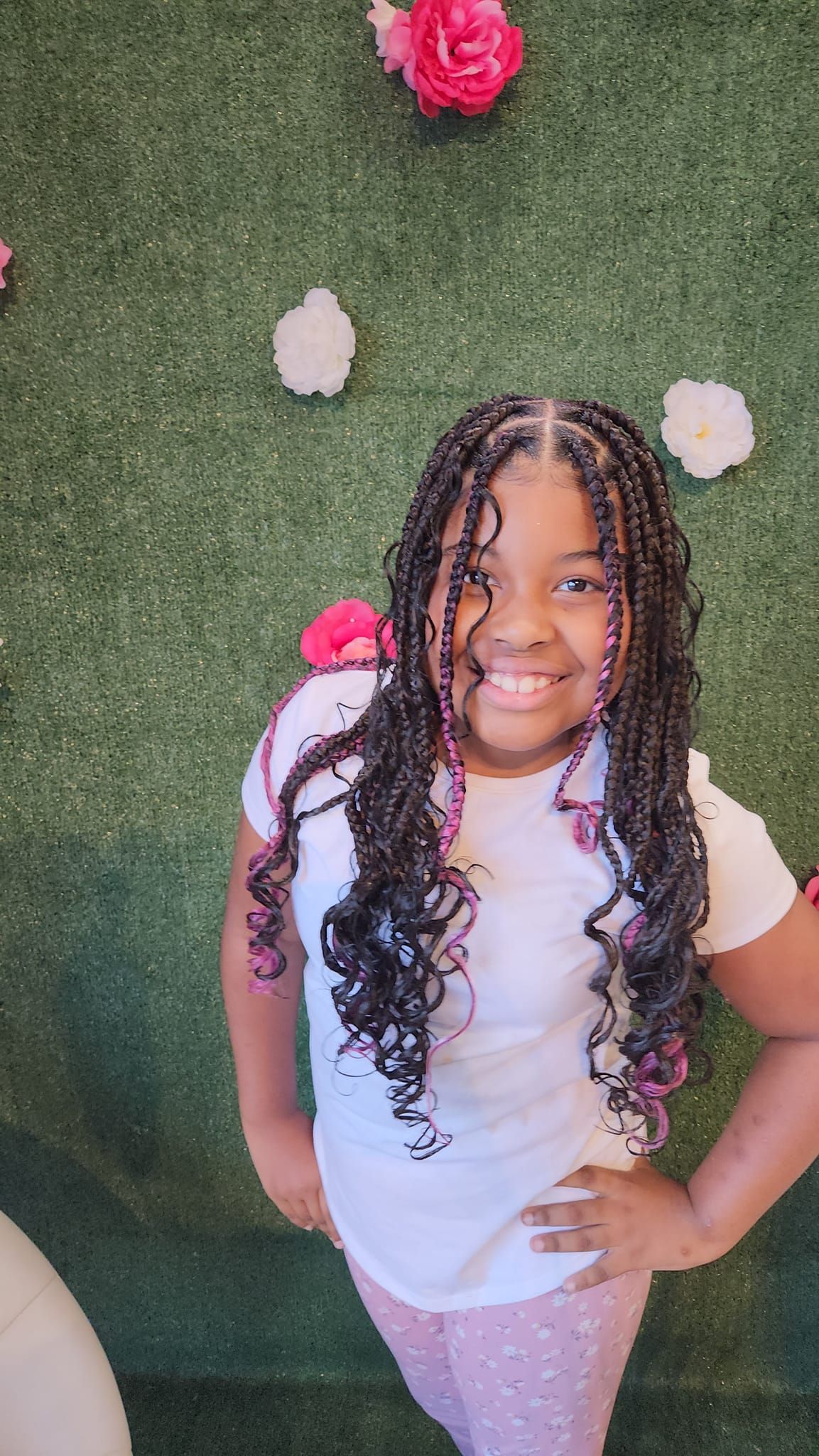 Braided hairstyle with pink ribbon accents being styled by hands