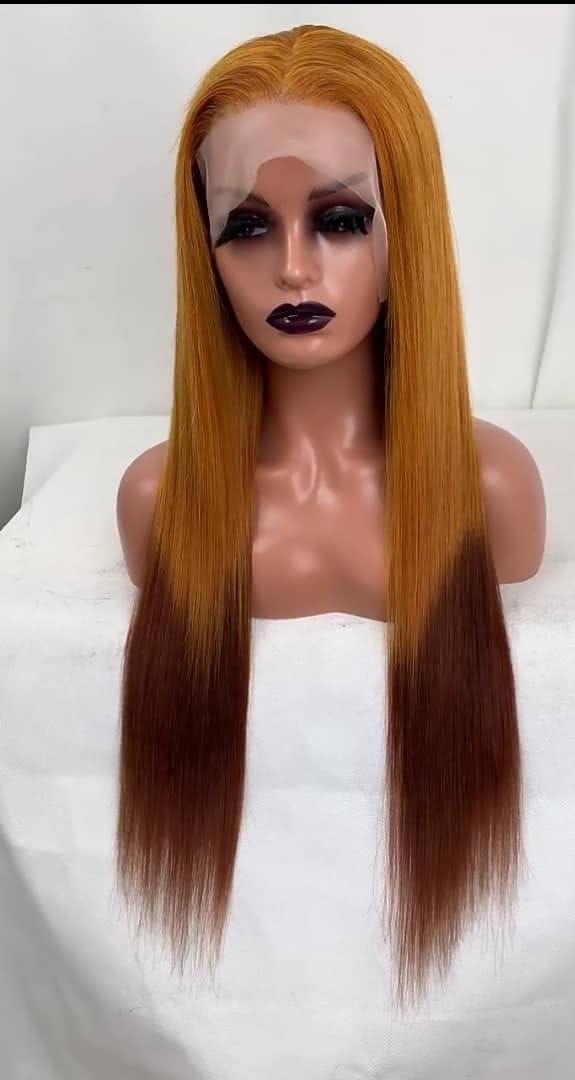 Mannequin head with long straight orange-to-brown ombré hair, dark makeup, and a white wrap top