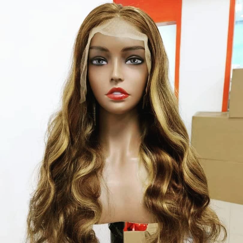 Mannequin head with long wavy blonde hair, red lips, and a neutral expression in a bright indoor setting