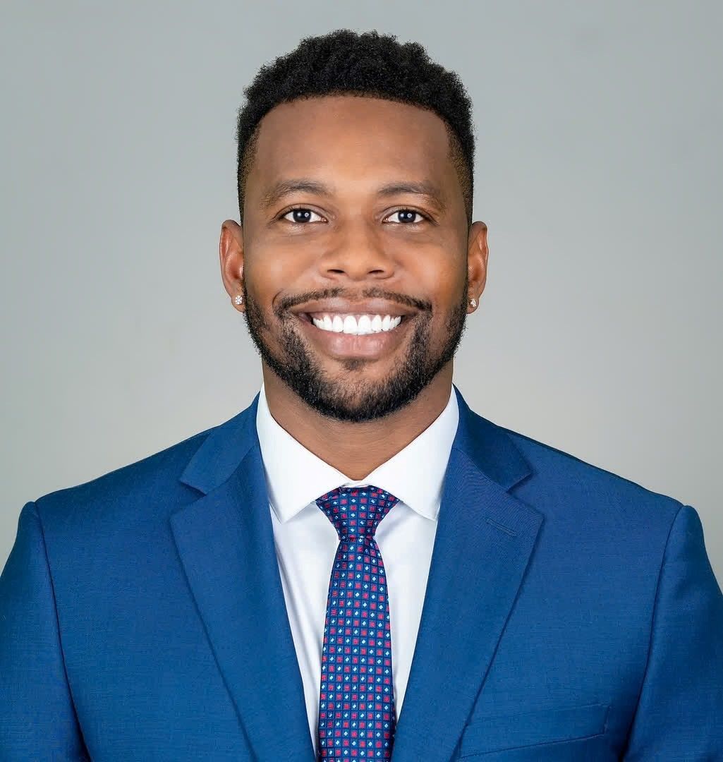 A man in a suit and tie is smiling for the camera.