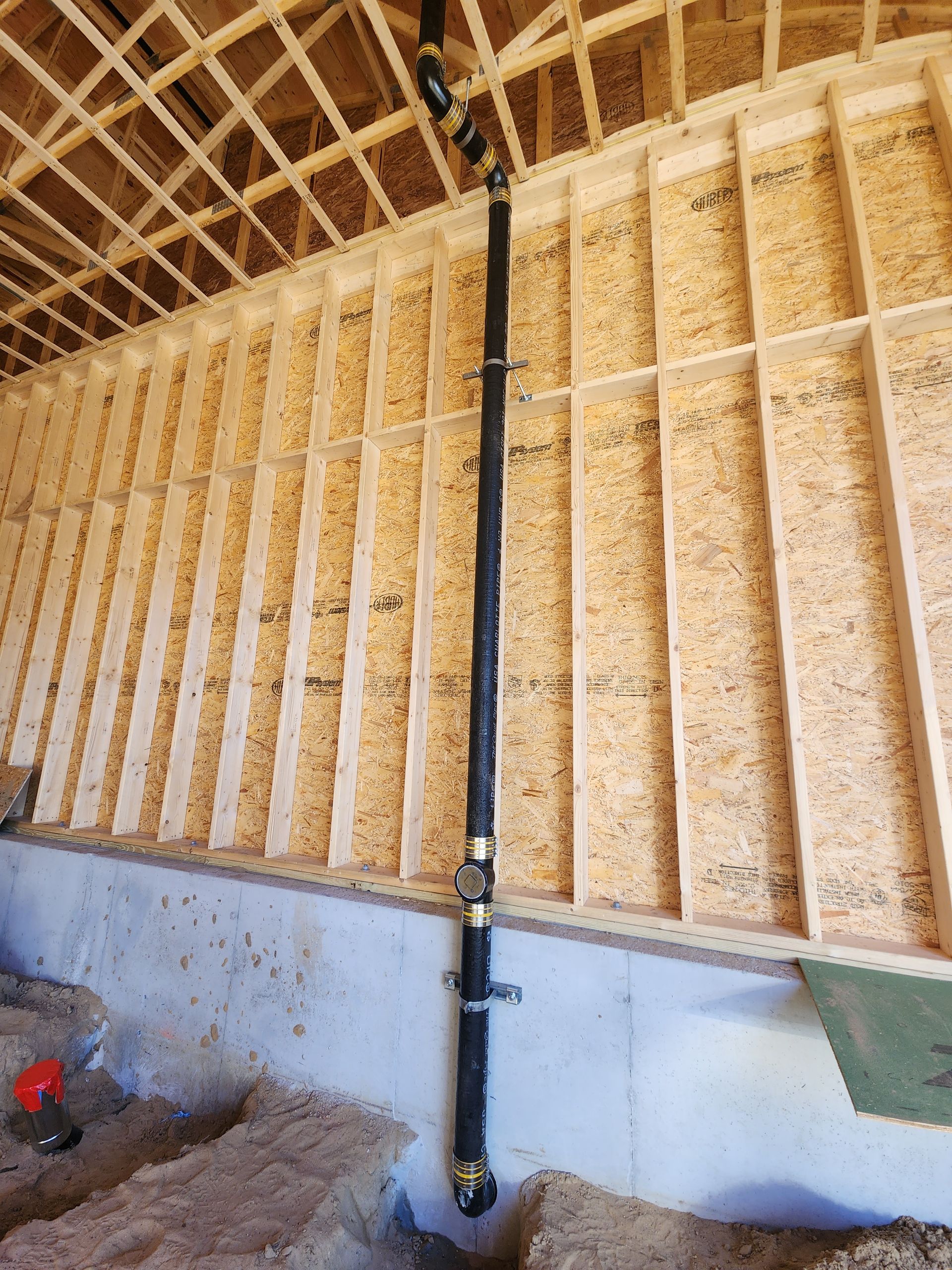 A pipe is hanging from the ceiling of a building under construction.