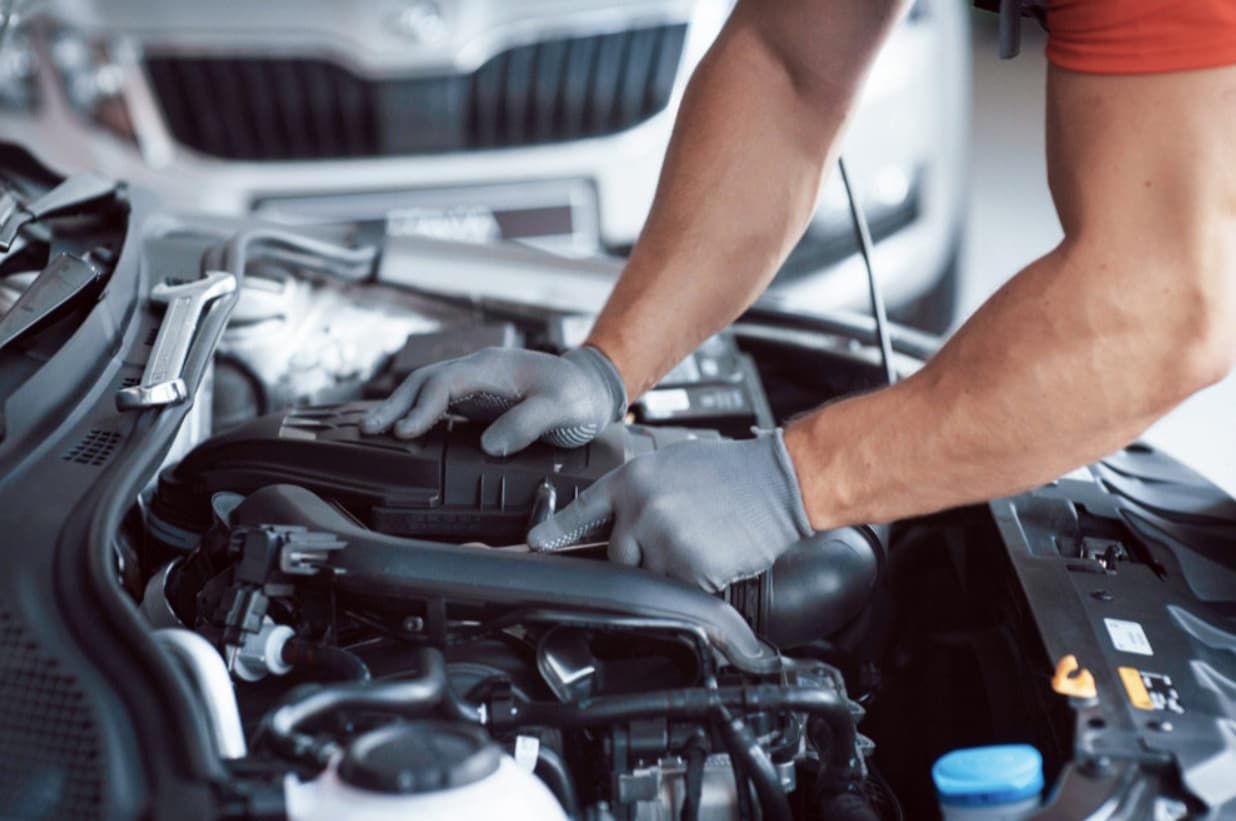 A Man Is Working On The Engine Of A Car — Uncle Tonys Auto And Mechanical In Currumbin Waters, QLD