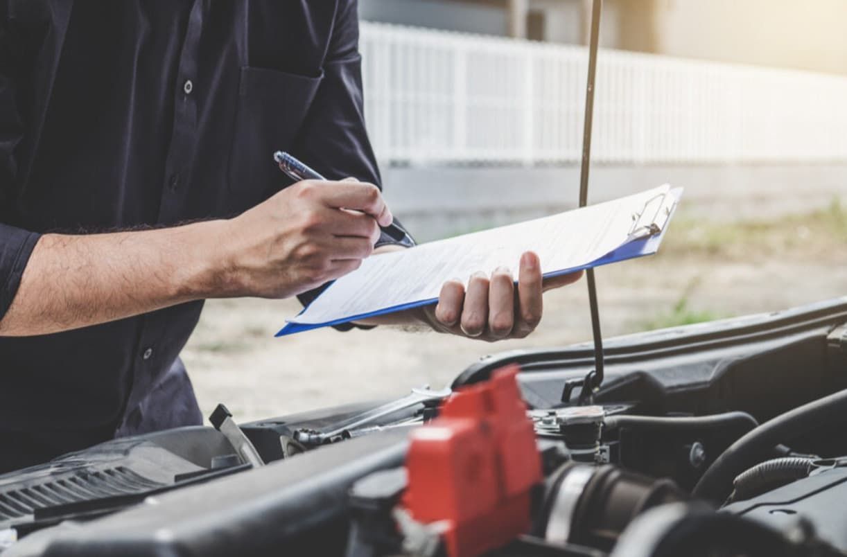 A Man Is Writing On A Logbook — Uncle Tonys Auto And Mechanical In Currumbin Waters, QLD