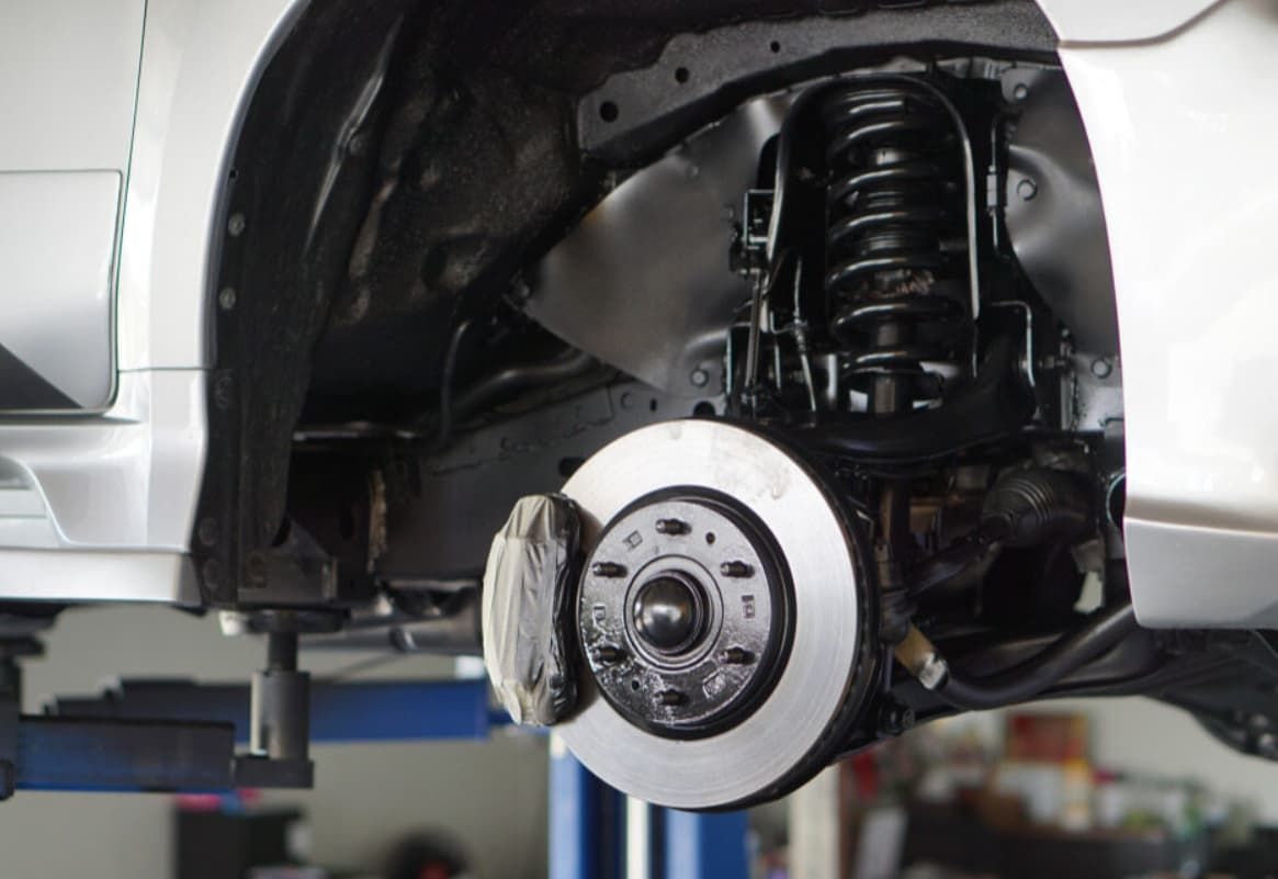 A Car Is Being Repaired On A Lift In A Garage — Uncle Tonys Auto And Mechanical In Currumbin Waters, QLD