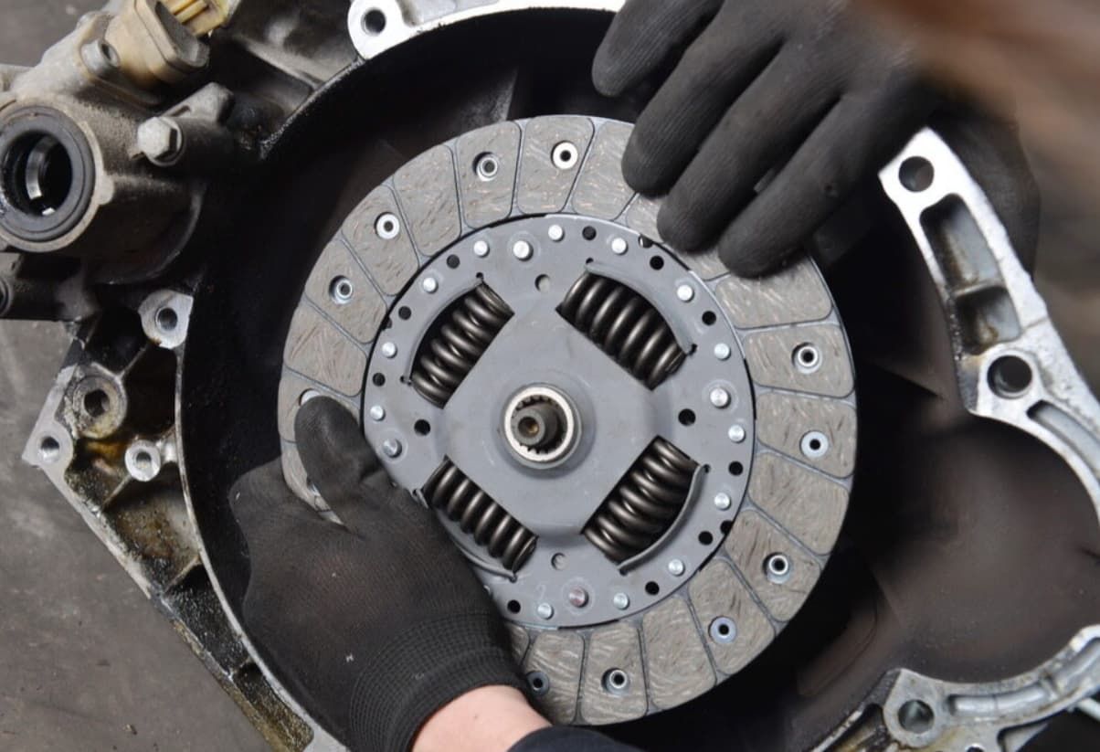 A Person Is Holding A Clutch Disc In Their Hands — Uncle Tonys Auto And Mechanical In Currumbin Waters, QLD