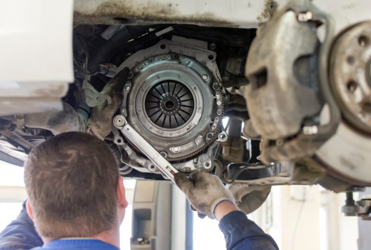 A Man Is Fixing A Clutch On A Car With A Wrench — Uncle Tonys Auto And Mechanical In Currumbin Waters, QLD