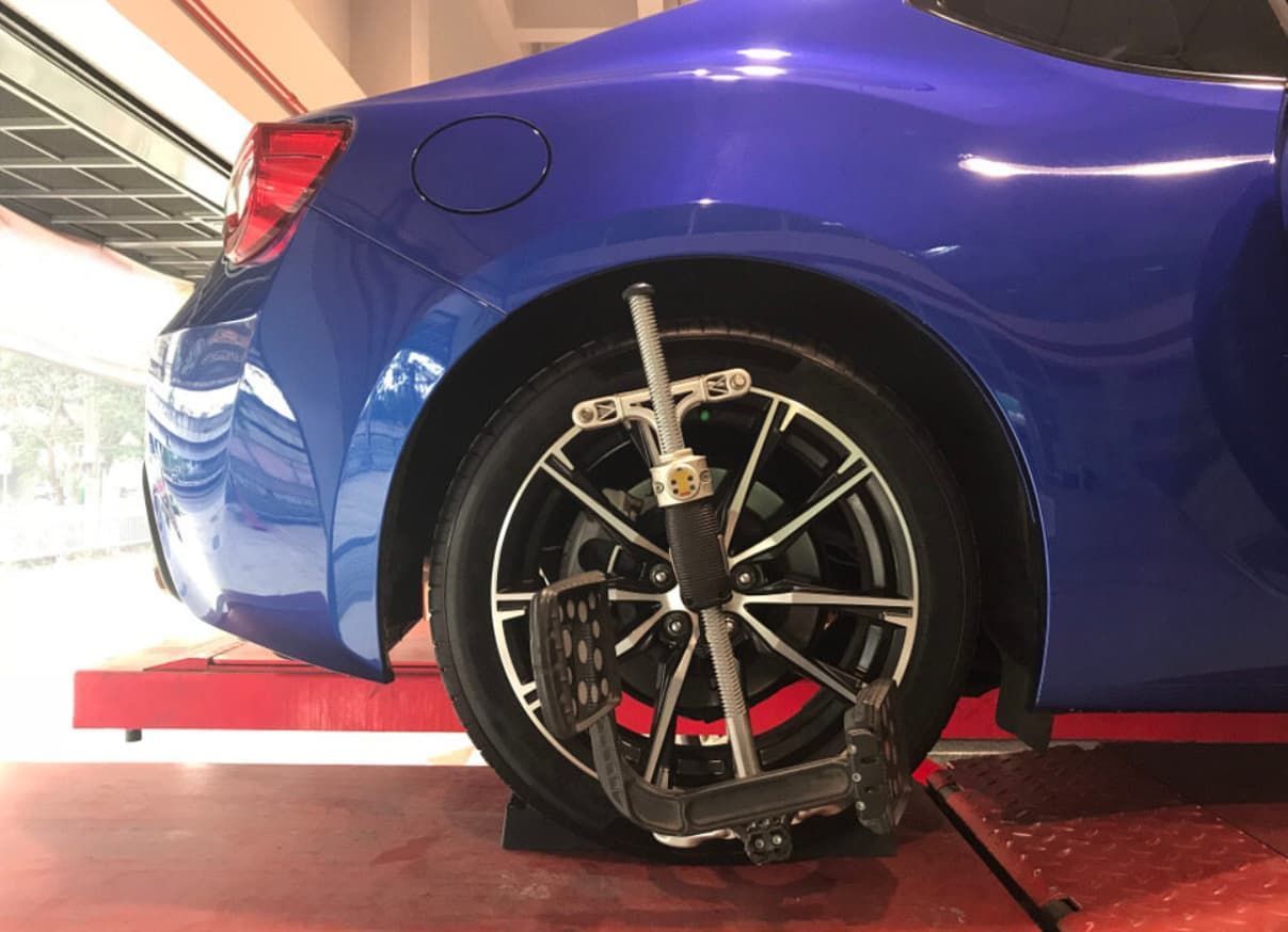 A Blue Car Is Being Adjusted By A Machine In A Garage — Uncle Tonys Auto And Mechanical In Currumbin Waters, QLD