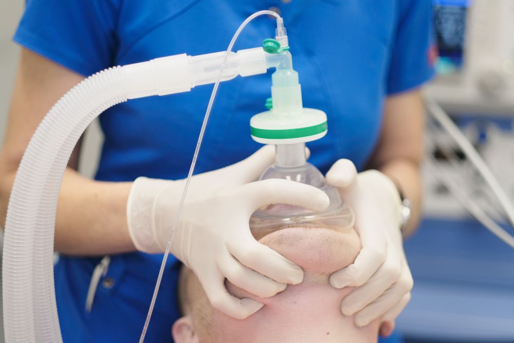 Medical professional uses oxygen mask on a patient.