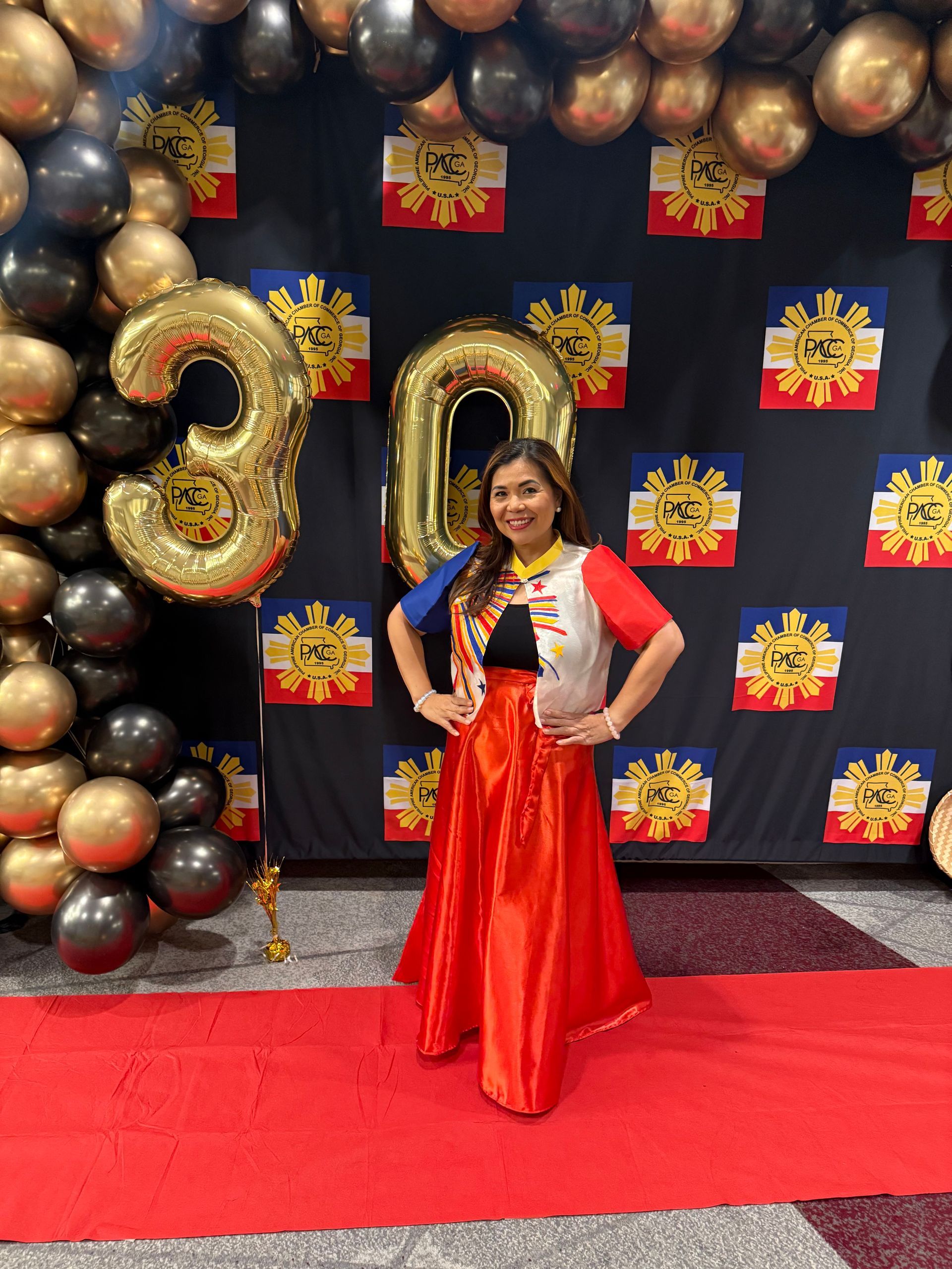 Woman in red and blue outfit poses near a 