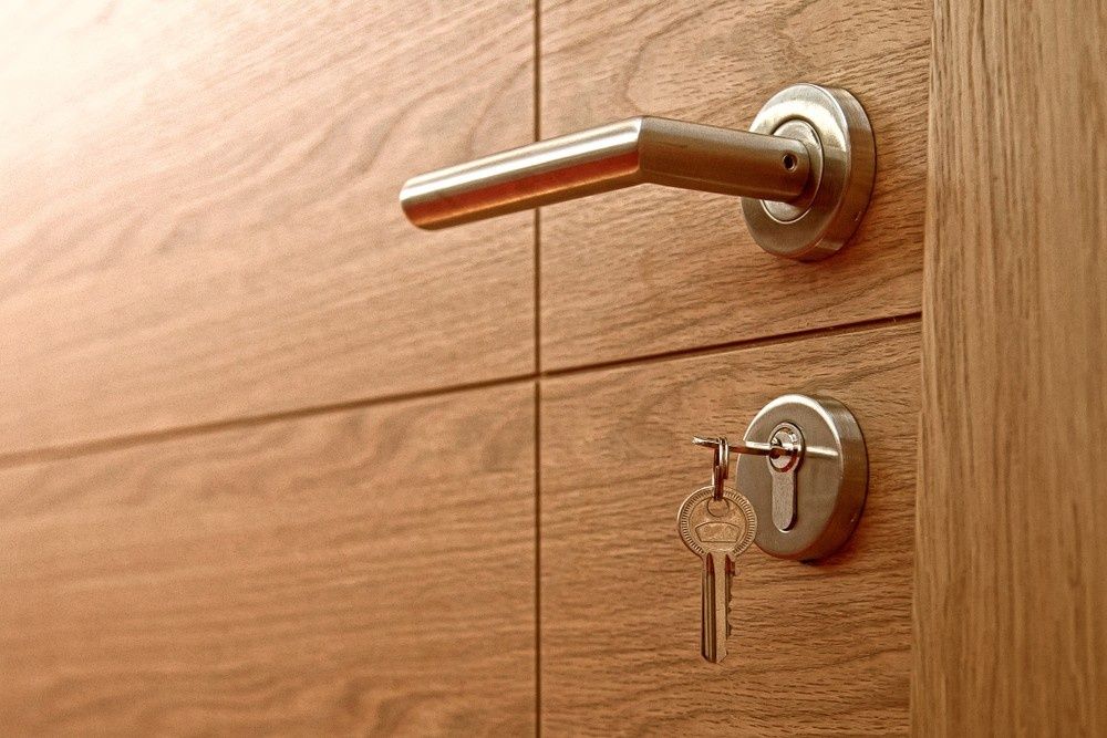 Door with Silver Handle, Key in Lock, Light Wood Panels — NORTHCOAST LOCKSMITHS & SECURITY In Forster, NSW