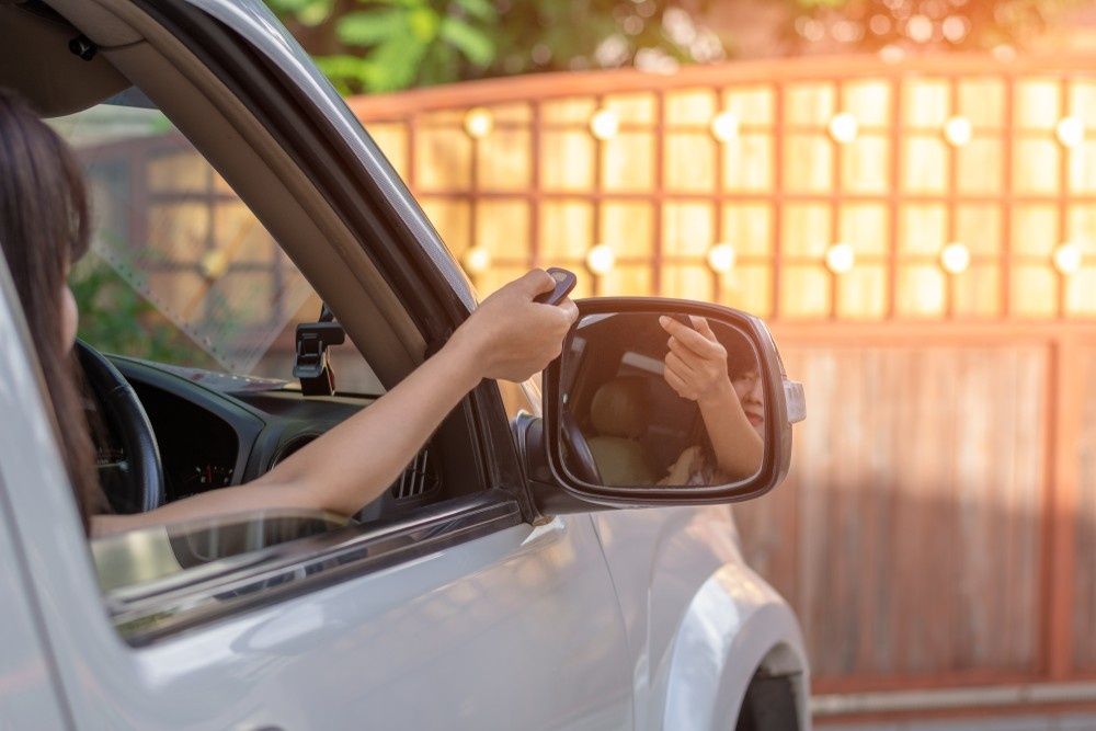 Woman in Car Using a Remote to Open a Gate — NORTHCOAST LOCKSMITHS & SECURITY In Pacific Palms, NSW