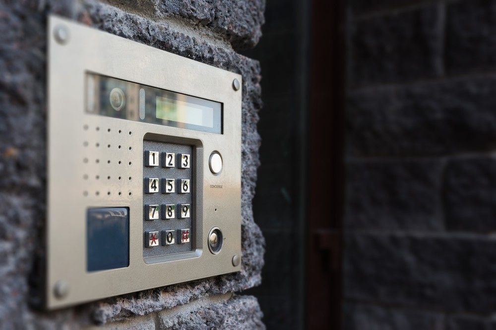Silver Intercom Keypad Mounted on A Dark Stone Wall — NORTHCOAST LOCKSMITHS & SECURITY In Diamond Beach, NSW