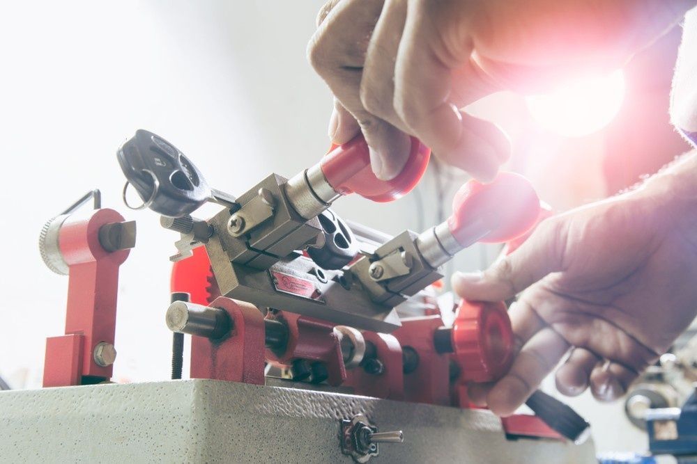 Person Cutting a Key with A Key-Duplicating Machine in A Workshop — NORTHCOAST LOCKSMITHS & SECURITY In Taree, NSW
