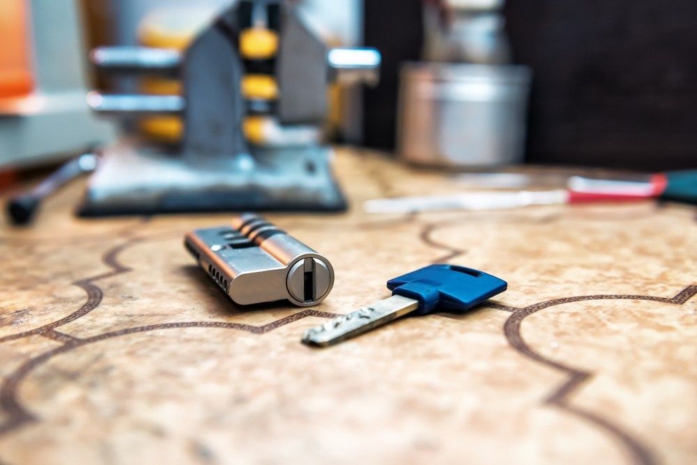 Lock Cylinder with Blue Key on A Patterned Surface — NORTHCOAST LOCKSMITHS & SECURITY In Nabiac, NSW