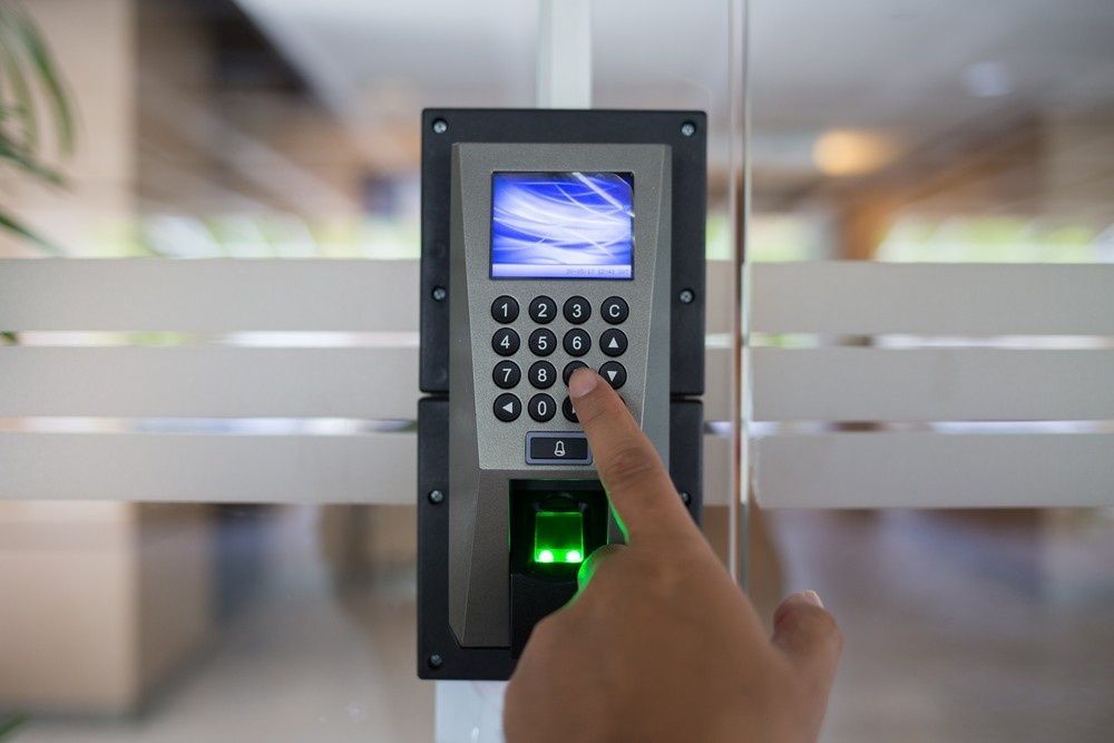 Person's Hand Using a Keypad and Fingerprint Scanner — NORTHCOAST LOCKSMITHS & SECURITY In Pacific Palms, NSW