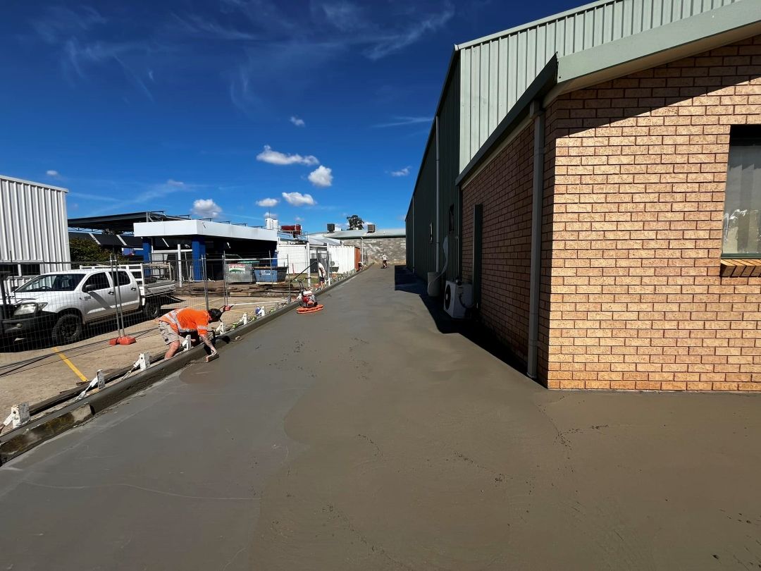 A Man is Working on a Concrete Driveway — All Aspects Concreting & Earthworks Pty Ltd in Wellington, NSW