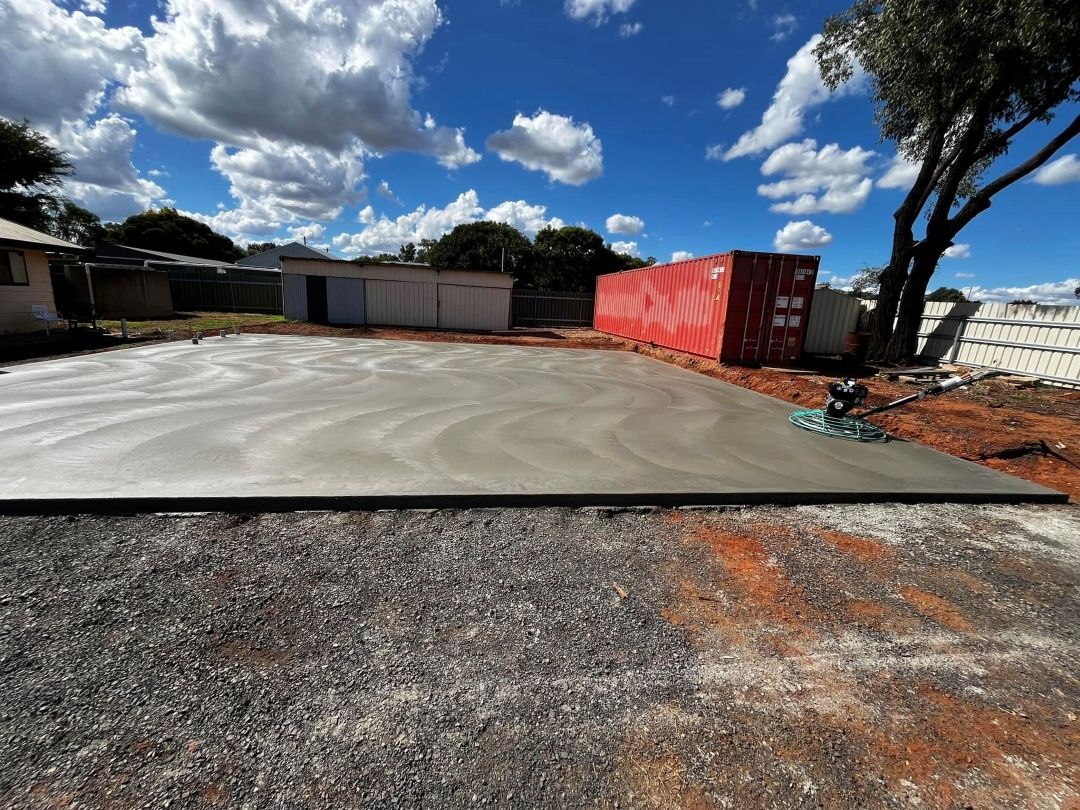 A Concrete Driveway With a Red Container in the Background — All Aspects Concreting & Earthworks Pty Ltd in Dubbo, NSW