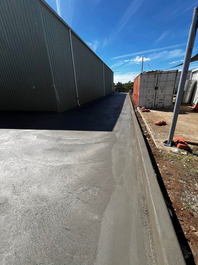 A Concrete Driveway is Being Built in Front of a Building — All Aspects Concreting & Earthworks Pty Ltd in Dubbo, NSW