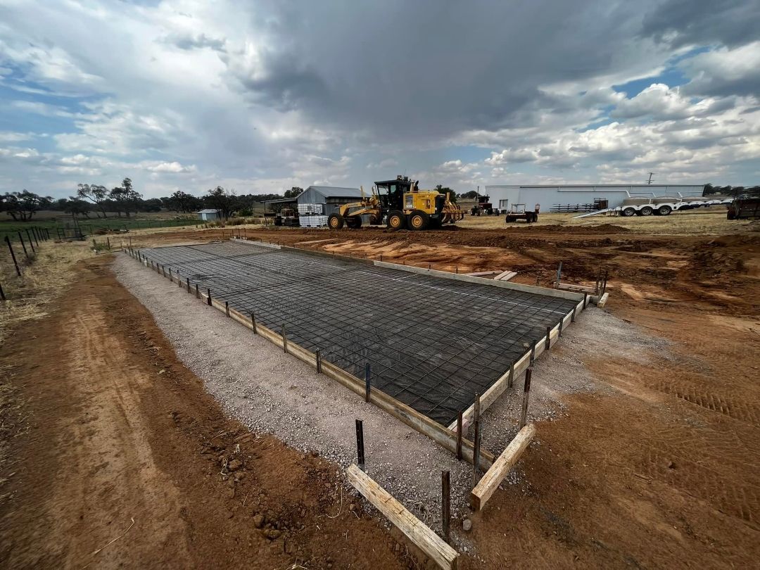 A Large Concrete Slab is Being Built on a Dirt Road — All Aspects Concreting & Earthworks Pty Ltd in Dubbo, NSW