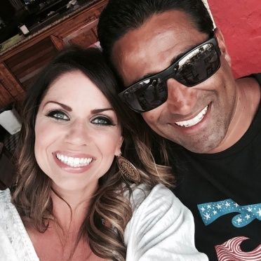 A man and a woman wearing sunglasses are smiling for the camera