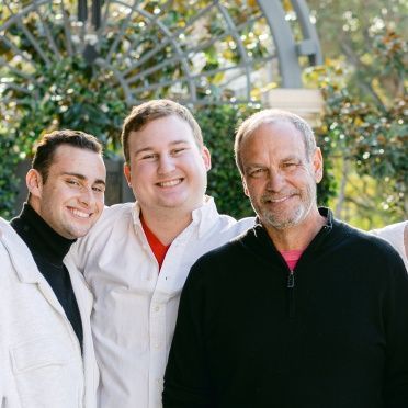 A group of men are posing for a picture and smiling