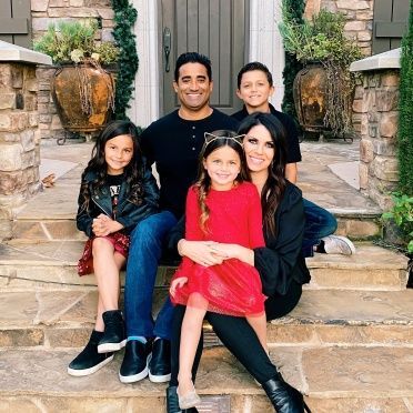 A family is posing for a picture on the steps of their house.