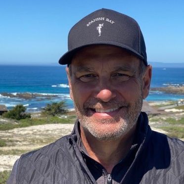 A man wearing a hat that says spanish bay
