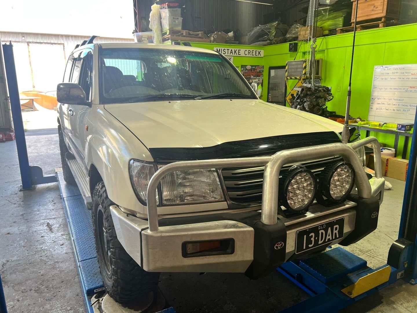 A White SUV Car On The Lift Inside The Garage — Chrisp Performance in Emerald, QLD