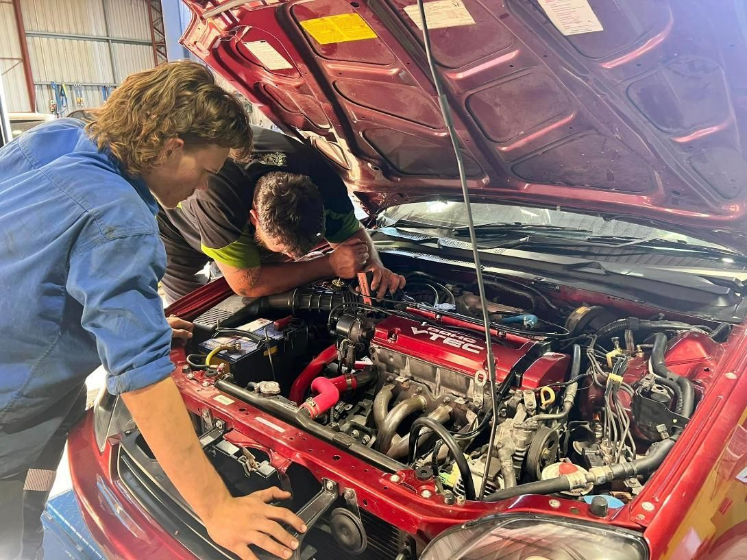 Two Men Are Working On The Engine Of A Red Car — Chrisp Performance in Emerald, QLD