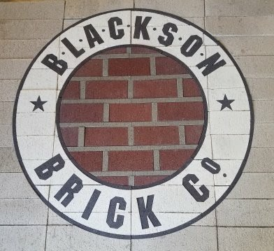 A logo for blackson brick co. is painted on a tiled floor