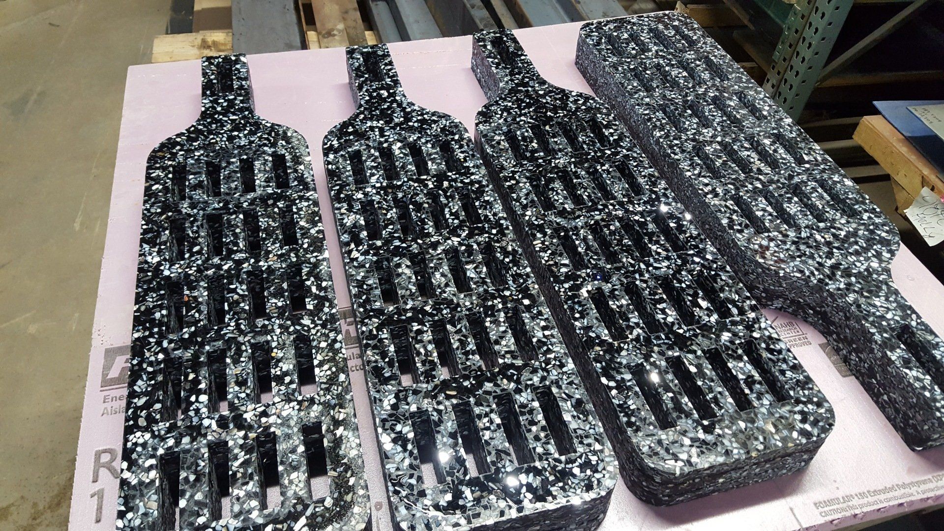 Three black and white bottles are sitting on a table.