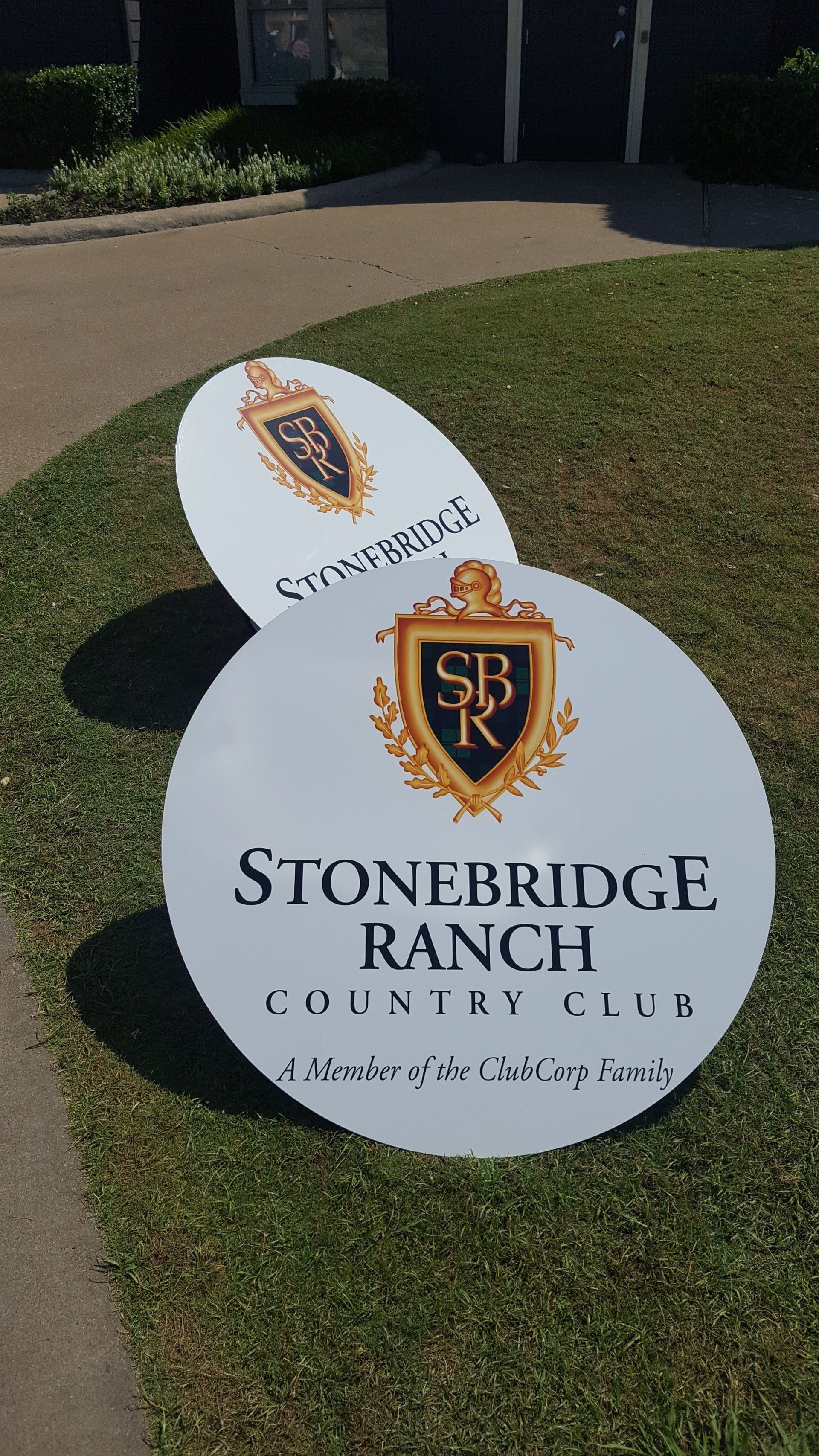 Two signs are sitting on top of each other in the grass.