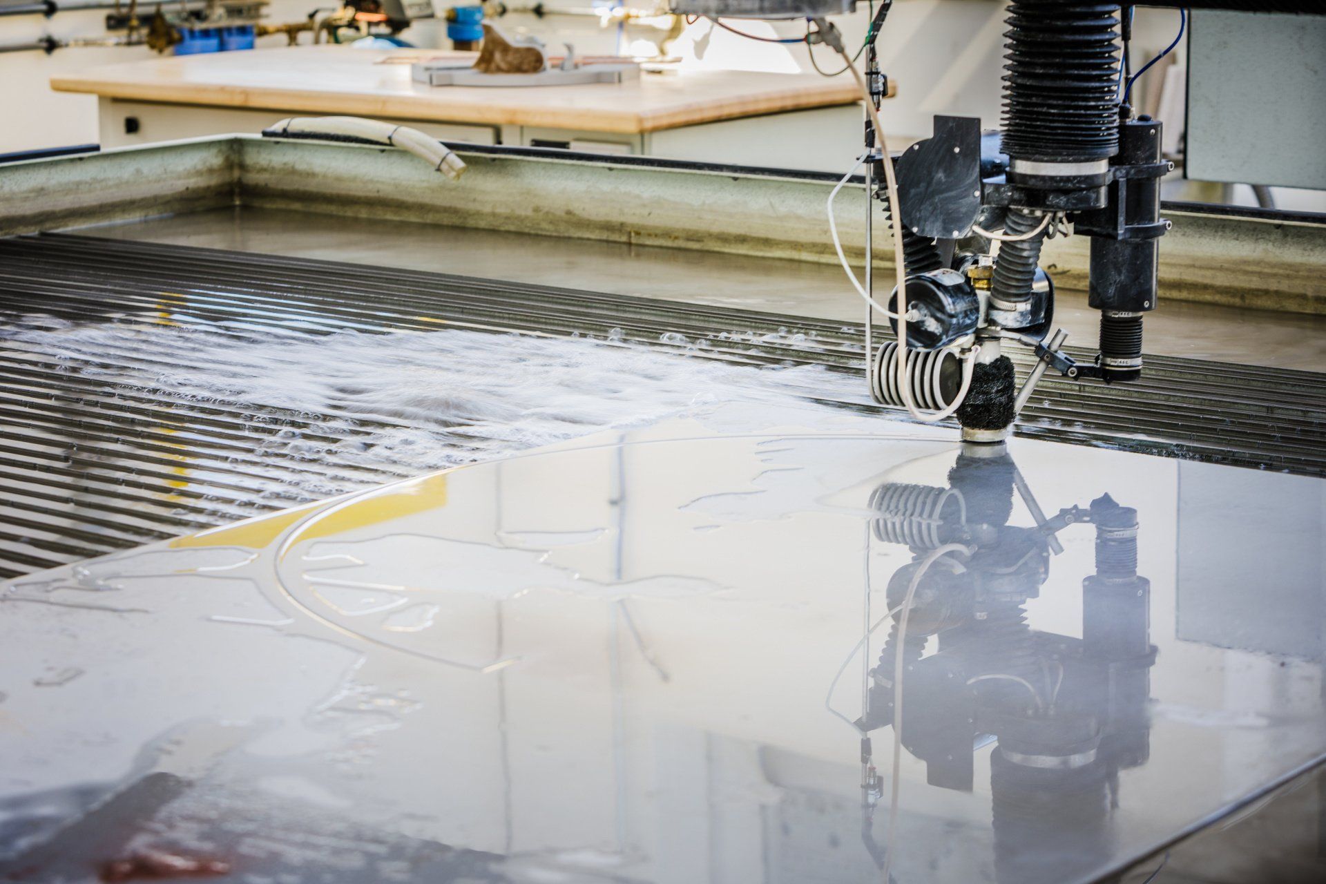 A machine is cutting a piece of glass with water.