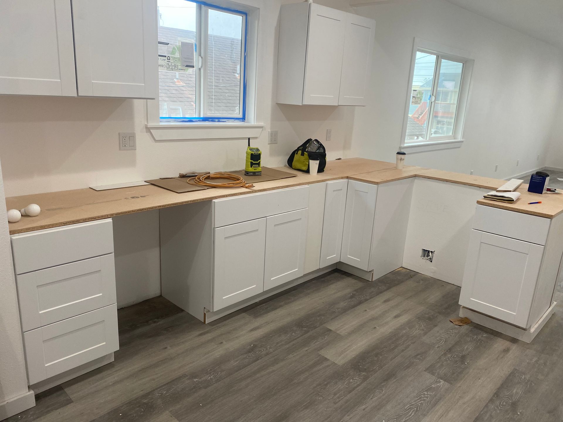 A kitchen with white cabinets and granite counter tops.