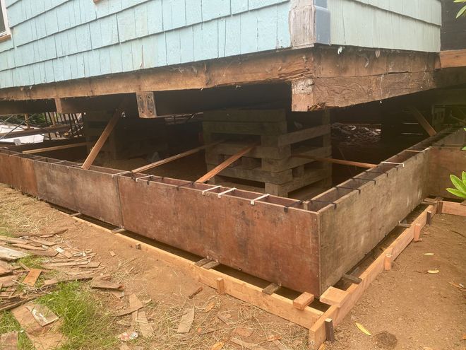 A house is being moved and the foundation is being built.