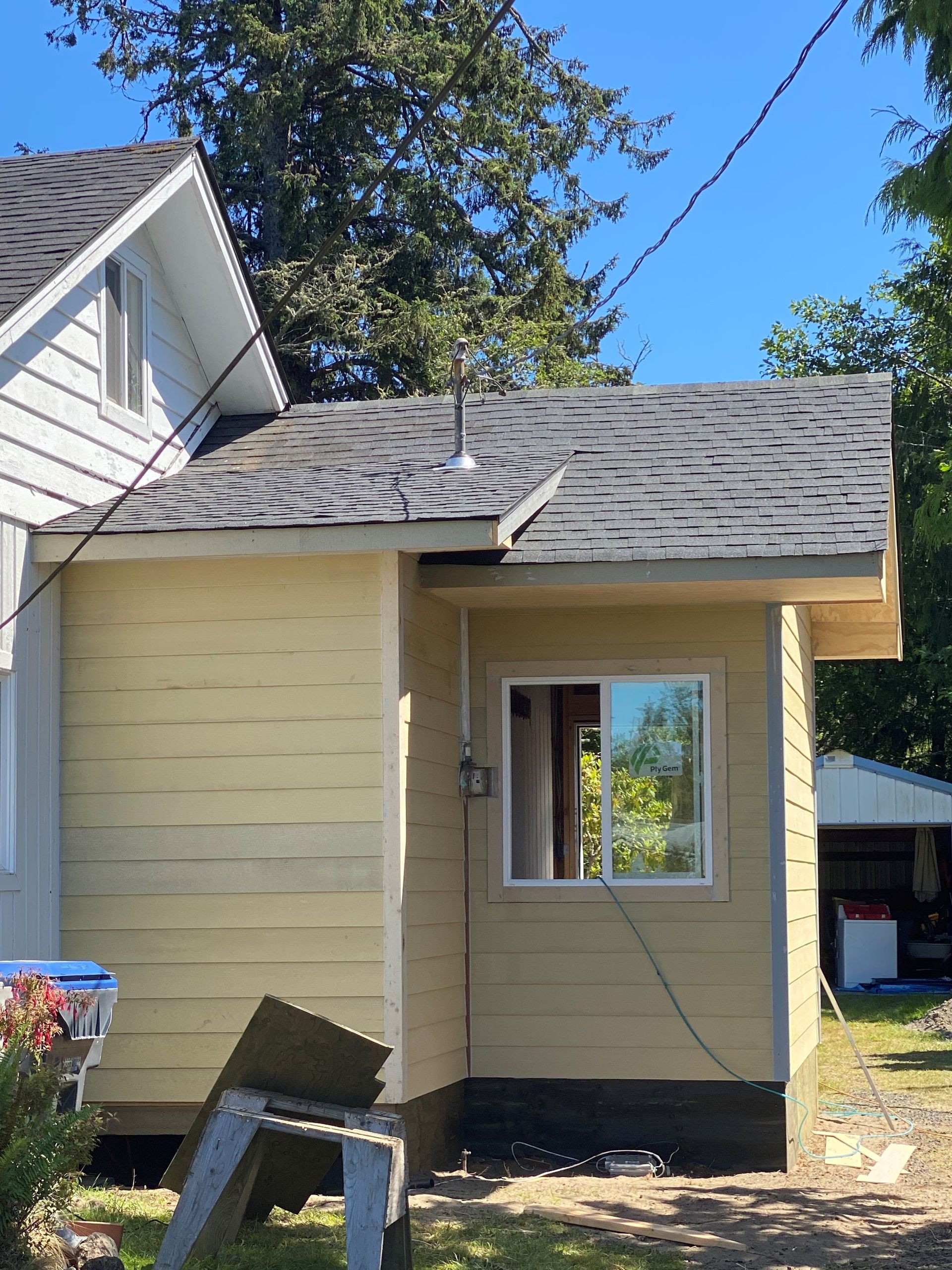 A small house with a window and a ladder in front of it.