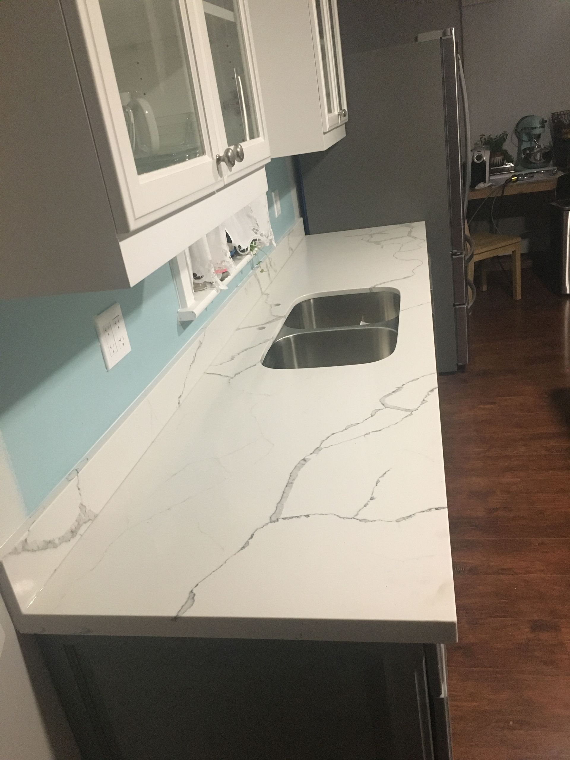 A kitchen with a white counter top and a sink.