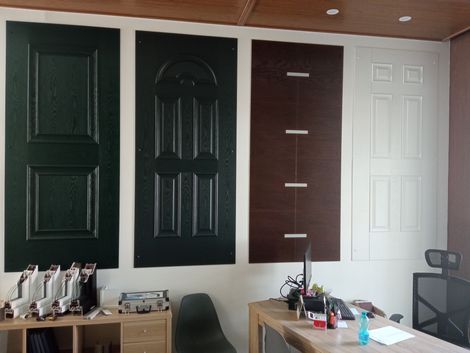 Durante una riunione in ufficio, una persona con un maglione rosso gesticola mentre parla con un uomo che indossa un maglione scuro e gli occhiali.