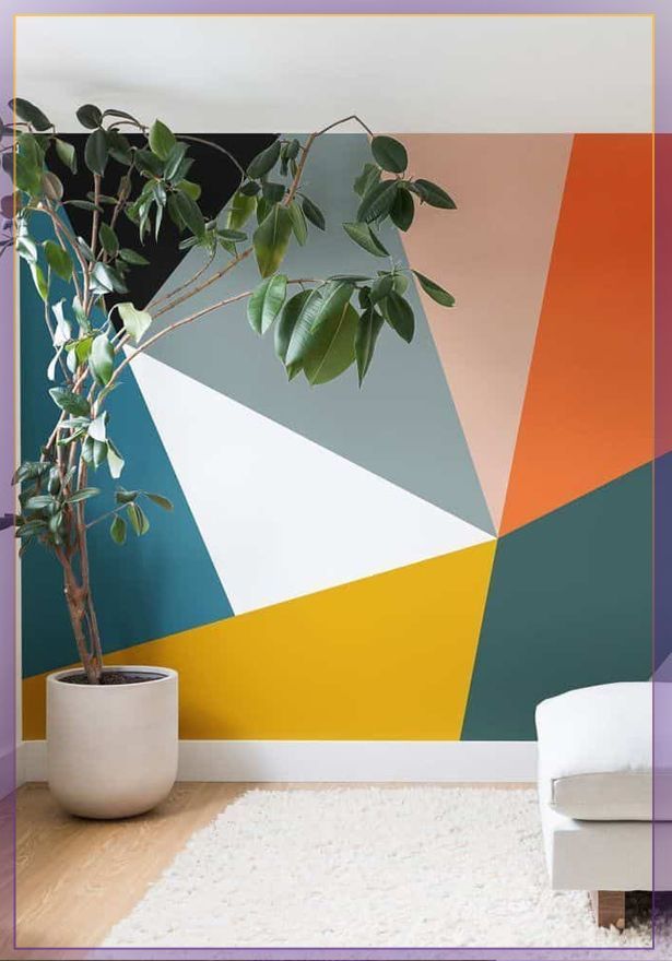 Modern room with geometric accent wall in teal, orange, yellow and white, plus a potted plant and white chair