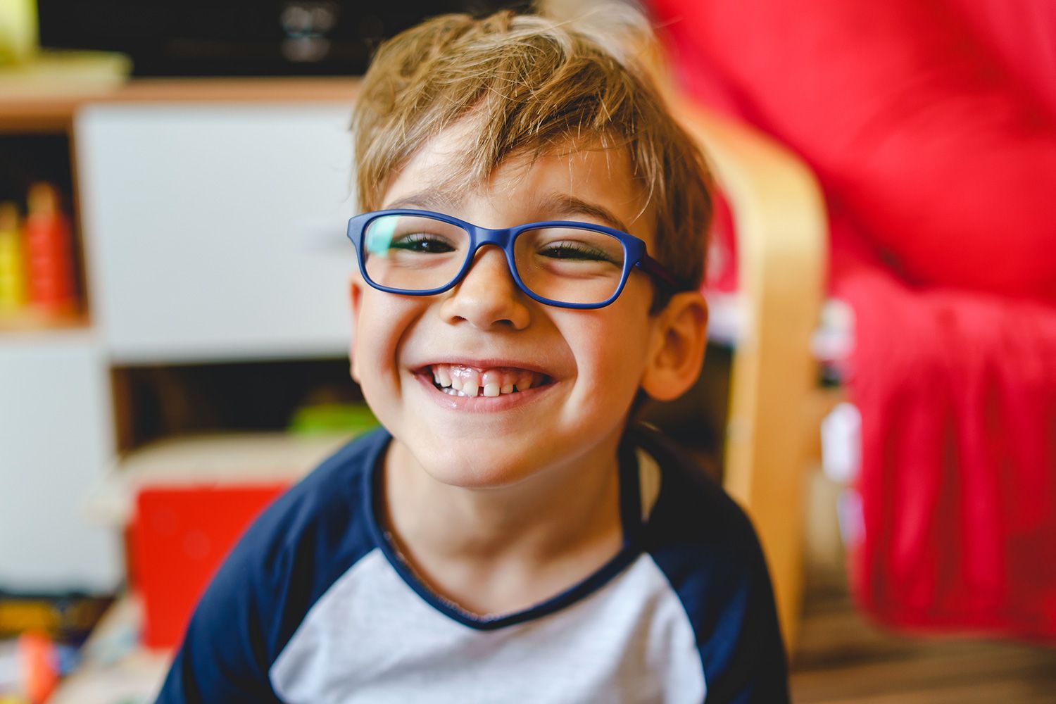 Smiling child wearing blue frame eyeglasses