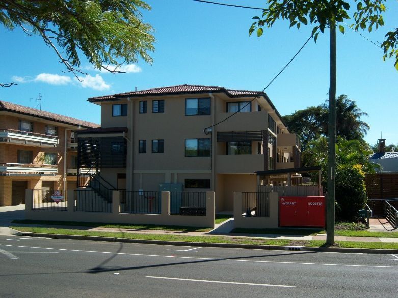 A Large Apartment Building With A Fence Around It — Certcorp DGL in Bundaberg South, QLD