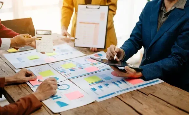 Team collaboration with charts and planning materials representing fractional supply chain support