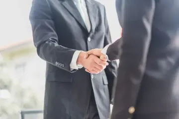 Two business professionals shaking hands representing FMCG partnerships and collaboration